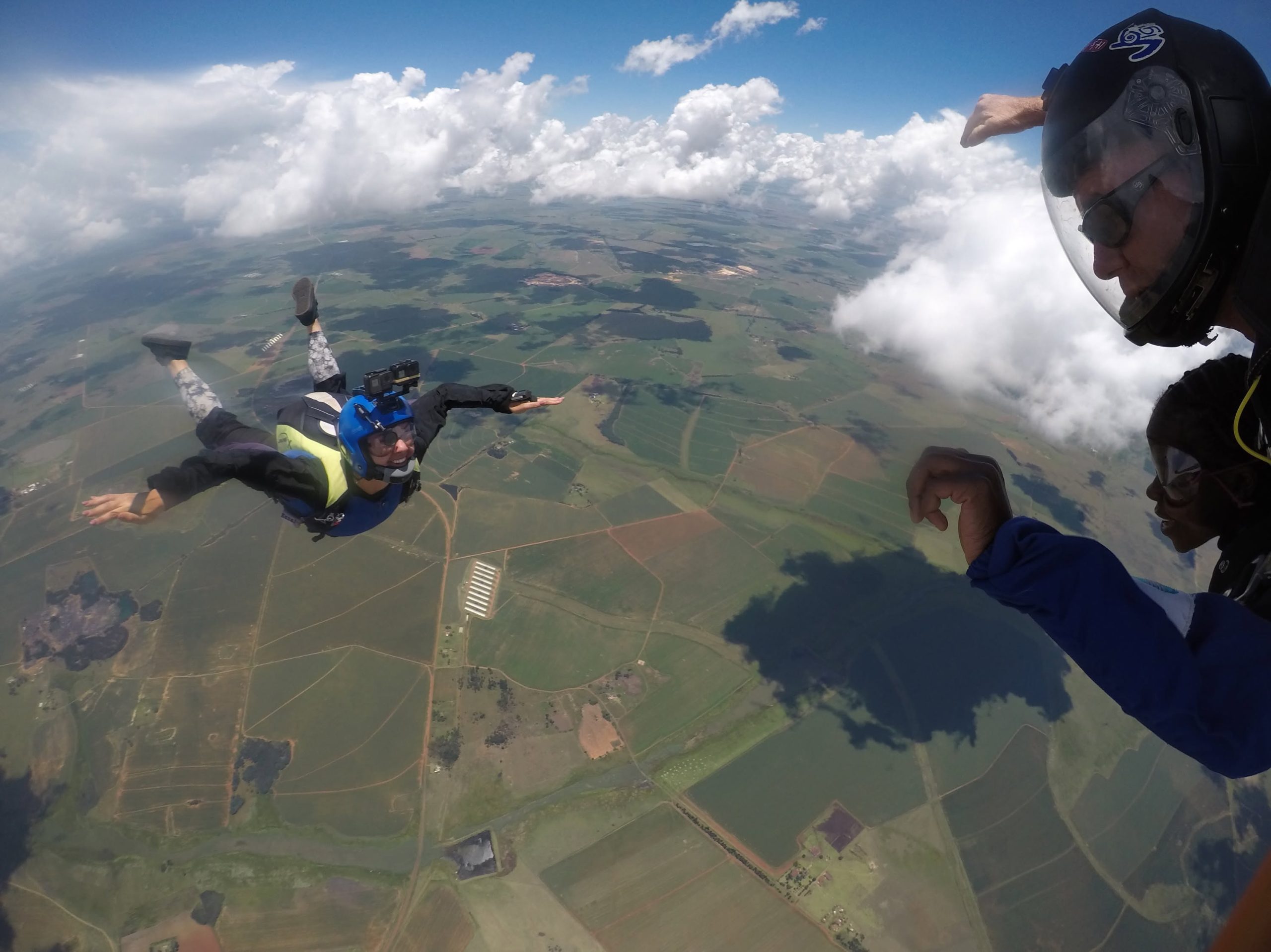 Tandem skydivers in freefall over Drakensberg farmland